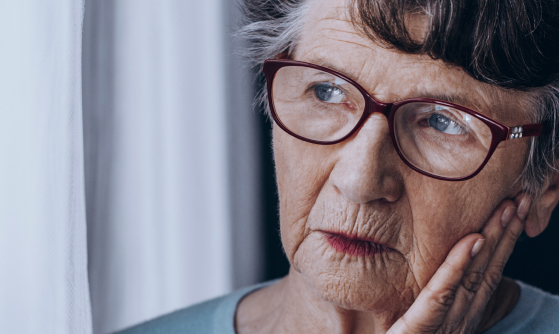 Задумчивая пожилая женщина в очках